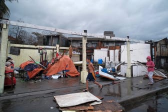 Kinder vor einem beschädtigten Haus: Der Sturm sorgte für Zerstörung, Überschwemmungen und Stromausfälle in dem Inselstaat.