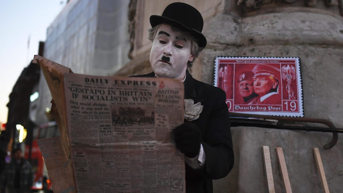 Ein als Charlie Chaplin verkleideter Mann demonstriert in London gegen den Nato-Gipfel und gegen den Besuch von Donald Trump.
