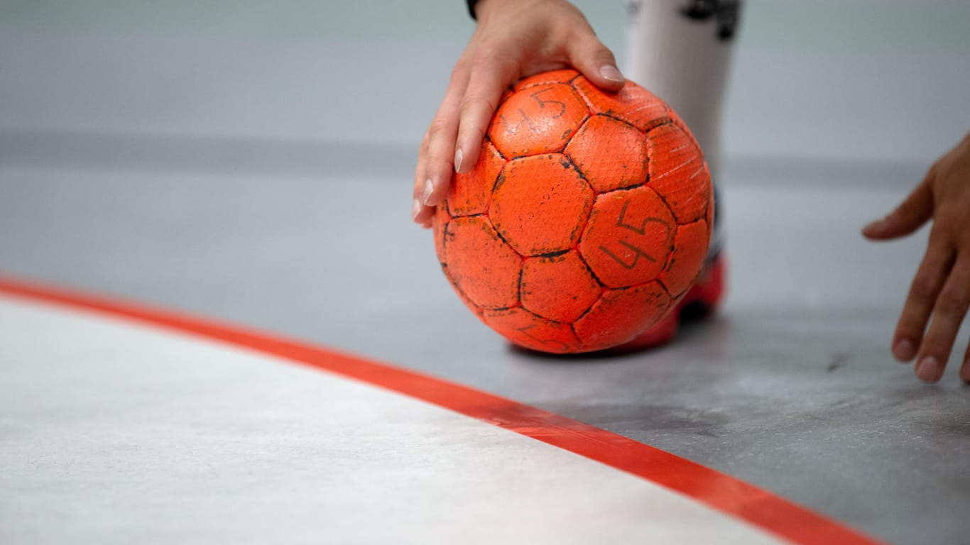 Ein Handballer hält einen Ball: In Essen ist ein junger Amateursportler kurz nach Spielbeginn zusammengebrochen und kurz darauf im Krankenhaus verstorben.