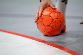 Ein Handballer hält einen Ball: In Essen ist ein junger Amateursportler kurz nach Spielbeginn zusammengebrochen und kurz darauf im Krankenhaus verstorben.