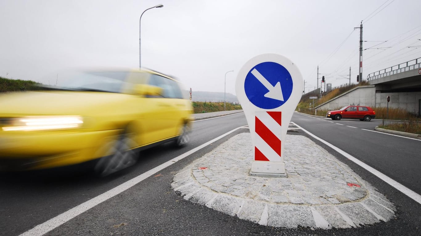 Ein Pkw fährt an einer Verkehrsinsel vorbei (Symbolbild): Im Straßenverkehr entscheiden oft Sekundenbruchteile über Leben und Tod.
