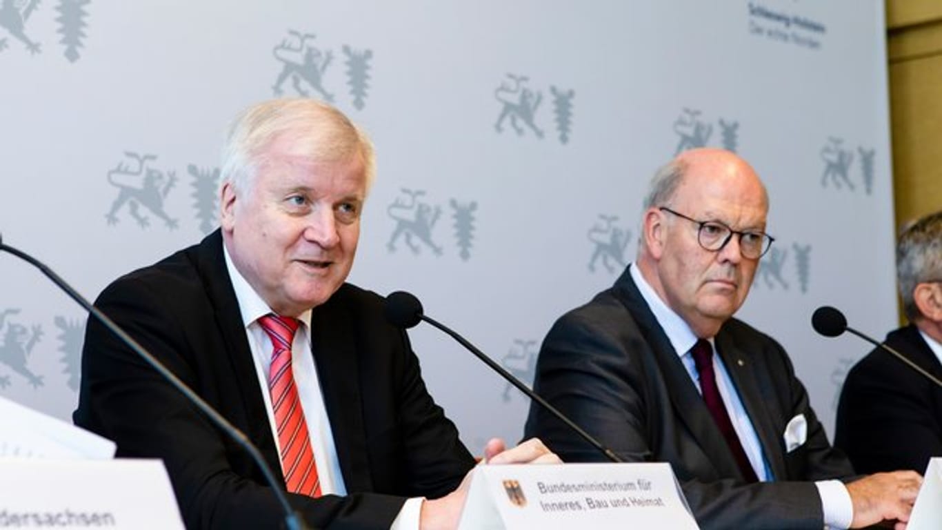 Auf der Innenministerkonferenz im schleswig-holsteinischen Kiel halten Bundesinnenminister Horst Seehofer (CSU, l-r) und Hans-Joachim Grote (CDU), Innenminister von Schleswig-Holstein, eine Pressekonferenz zusammen.