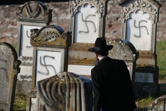 Hakenkreuze auf jüdischen Gräbern: Harold Abraham Weill, Oberrabbiner von Straßburg, betrachtet den geschändeten Friedhof von Westhoffen.