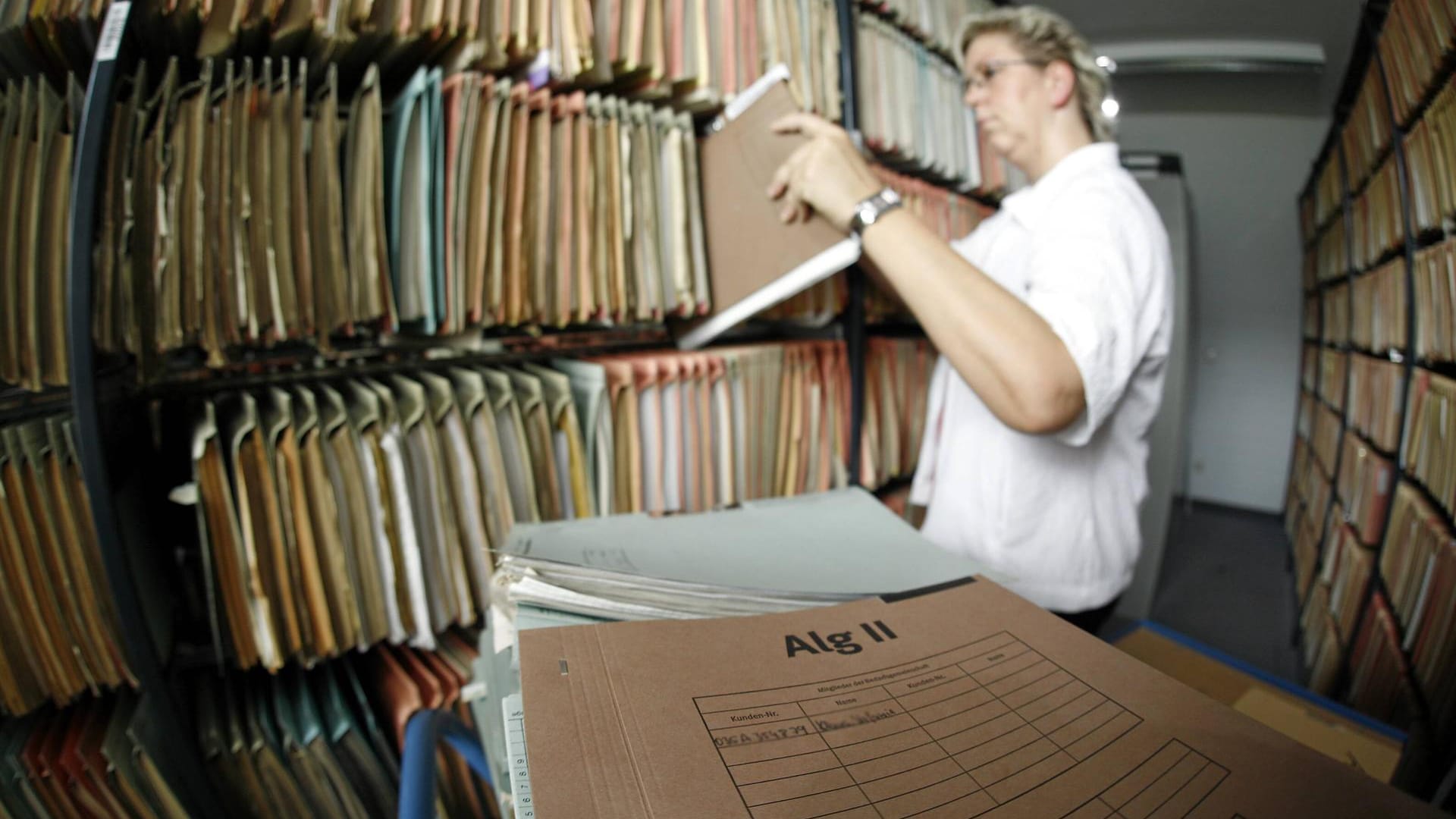 Mitarbeiterin der Arbeitsagentur zwischen Aktenregalen (Symbolbild): Am wenigsten zufrieden sind Bürger mit Dienstleistungen bei Jobcenter, Wohnungsamt und BAfög-Amt.