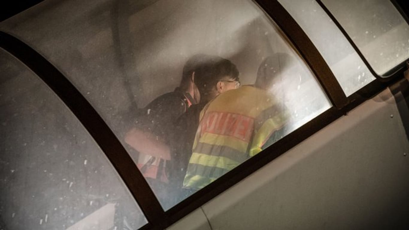 Polizeibeamte begleiten einen abgewiesenen Asylbewerber zum Flugzeug.