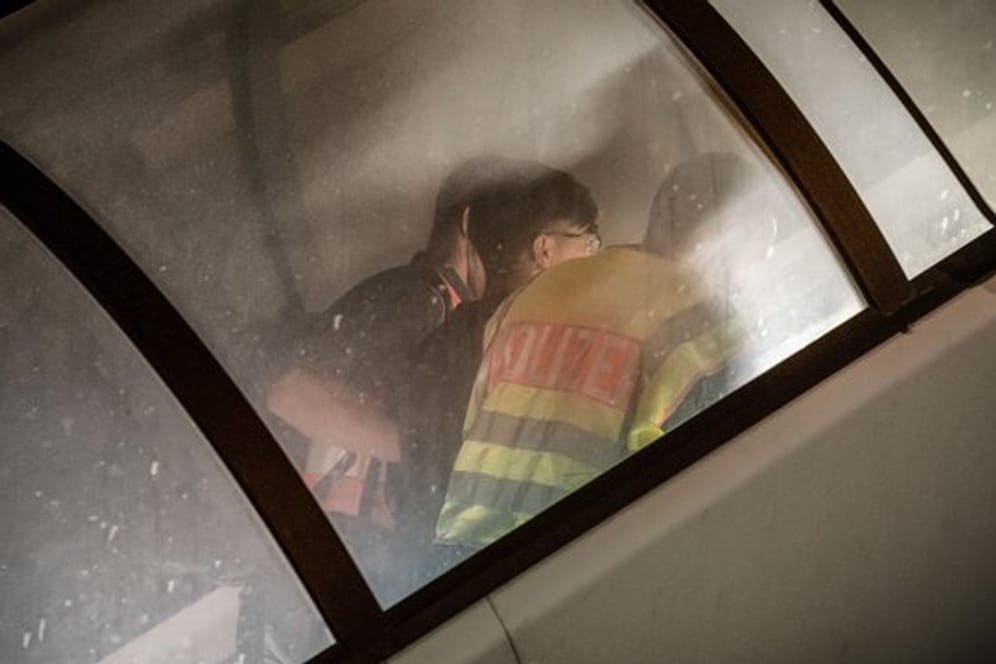 Polizeibeamte begleiten einen abgewiesenen Asylbewerber zum Flugzeug.