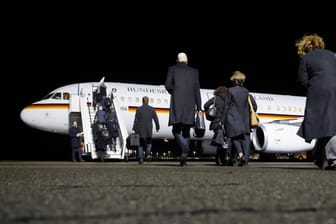 Mitglieder einer Delegation: Sie gehen über das Flugfeld zu einer deutschen Regierungsmaschine.
