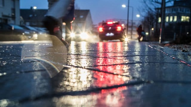 Eine Person geht auf einer vereisten Straße spazieren (Symbolbild): Am Montag besteht in Bremen große Glättegefahr.