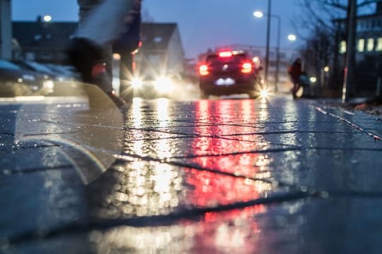 Eine Person geht auf einer vereisten Straße spazieren (Symbolbild): Am Montag besteht in Bremen große Glättegefahr.