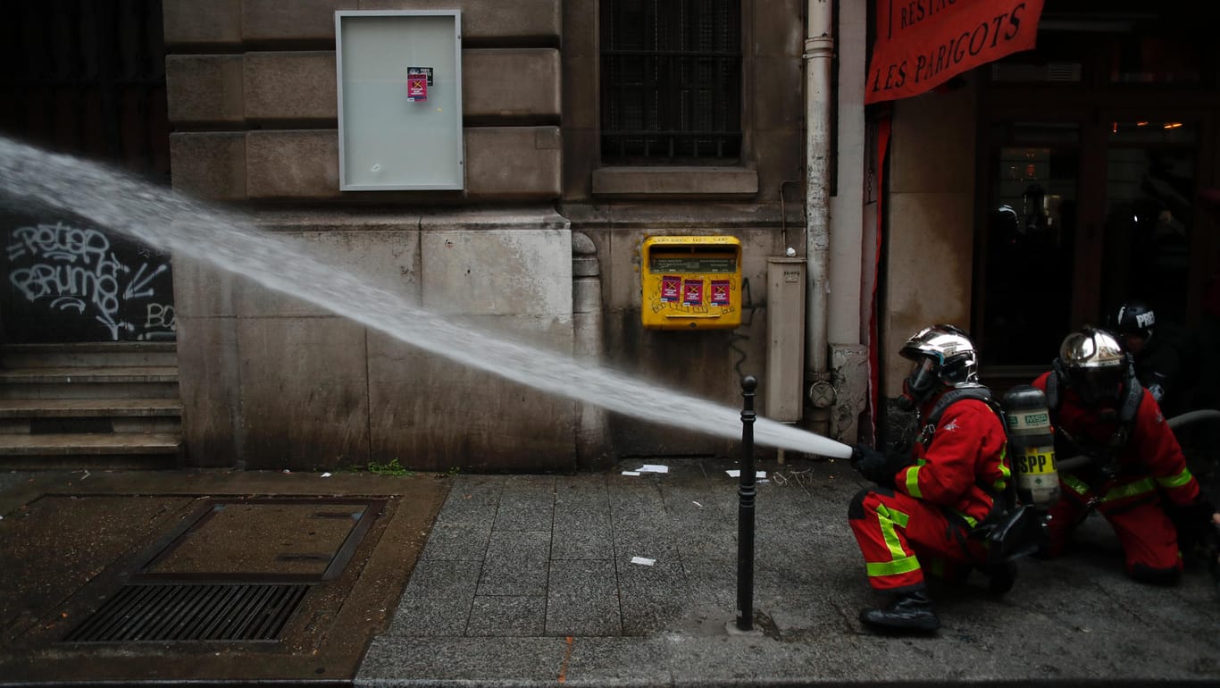 Ausschreitungen in Paris: Feuerwehrleute löschen einen brennenden Lastwagen.