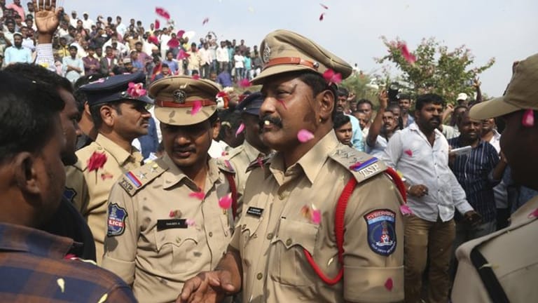 Indische Polizisten bewachen ein Gebiet etwa 50 Kilometer von Hyderabad, in dem vier mutmaßliche Vergewaltiger von der Polizei erschossen wurden.