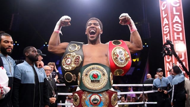 Anthony Joshua feiert seinen Sieg: Der Brite hat sich die Weltmeistergürtel der Verbände WBO, WBA, IBF und IBO umgehängt.