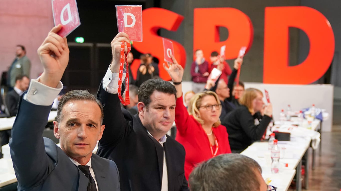 Heiko Maas, Hubertus Heil und Svenja Schulze (l-r, alle SPD) halten ihre Stimmkarten hoch: Die Partei entschied sich für den Verbleib in der Groko – vorerst.
