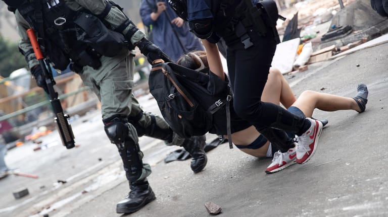 Polizisten in Hongkong tragen Demonstranten weg: Amnesty International hat den Einsatz von Gewalt gegen friedliche Demonstranten durch Sicherheitskräfte kritisiert. (Symbolbild)