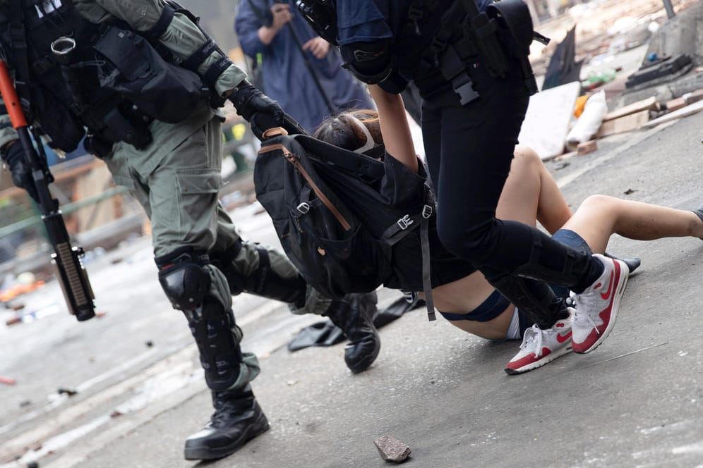 Polizisten in Hongkong tragen Demonstranten weg: Amnesty International hat den Einsatz von Gewalt gegen friedliche Demonstranten durch Sicherheitskräfte kritisiert. (Symbolbild)