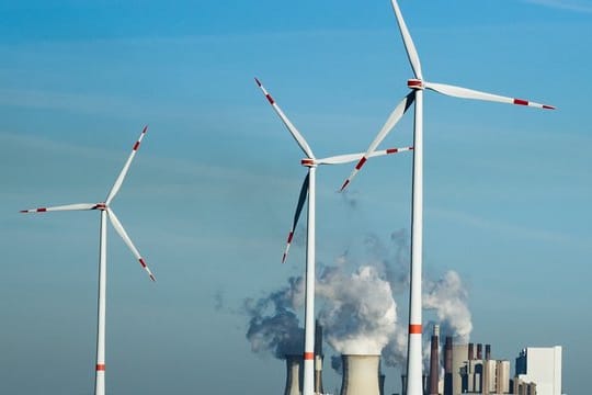 Windräder stehen vor dem Braunkohlekraftwerk Neurath.