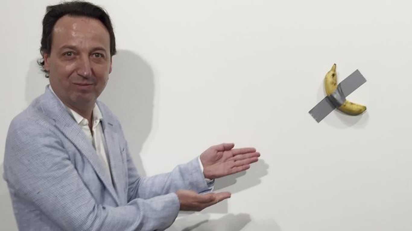 Galerist Emmanuel Perrotin zeigt auf das Kunstwerk "Comedian" von Maurizio Cattelan auf der Art Basel in Miami.