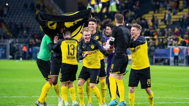 Nach dem Spiel gegen Slavia Prag tanzen Dortmunds Spieler erleichtert vor den Fans auf dem Spielfeld. Nach dem Spiel gegen Slavia Prag tanzen Dortmunds Spieler erleichtert vor den Fans auf dem Spielfeld.