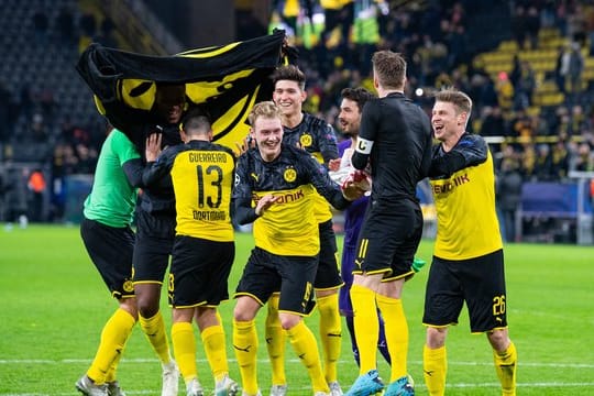 Nach dem Spiel gegen Slavia Prag tanzen Dortmunds Spieler erleichtert vor den Fans auf dem Spielfeld.