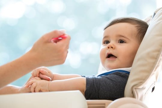 Baby wird gefüttert: Sobald sich Kinder für das Essen von Mama oder Papa interessieren, können Eltern den Beikost-Start versuchen.