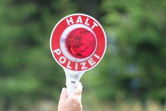 Eine Polizistin hält eine Winkerkelle in die Höhe