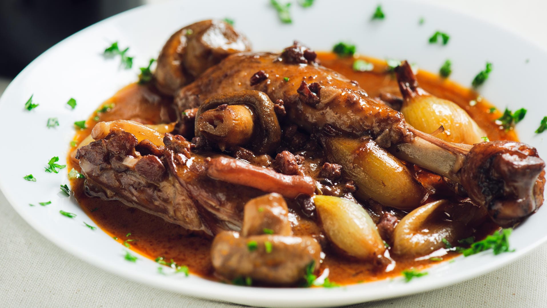 Coq au Vin: Das Fleisch schmort in Rotwein und Fond.