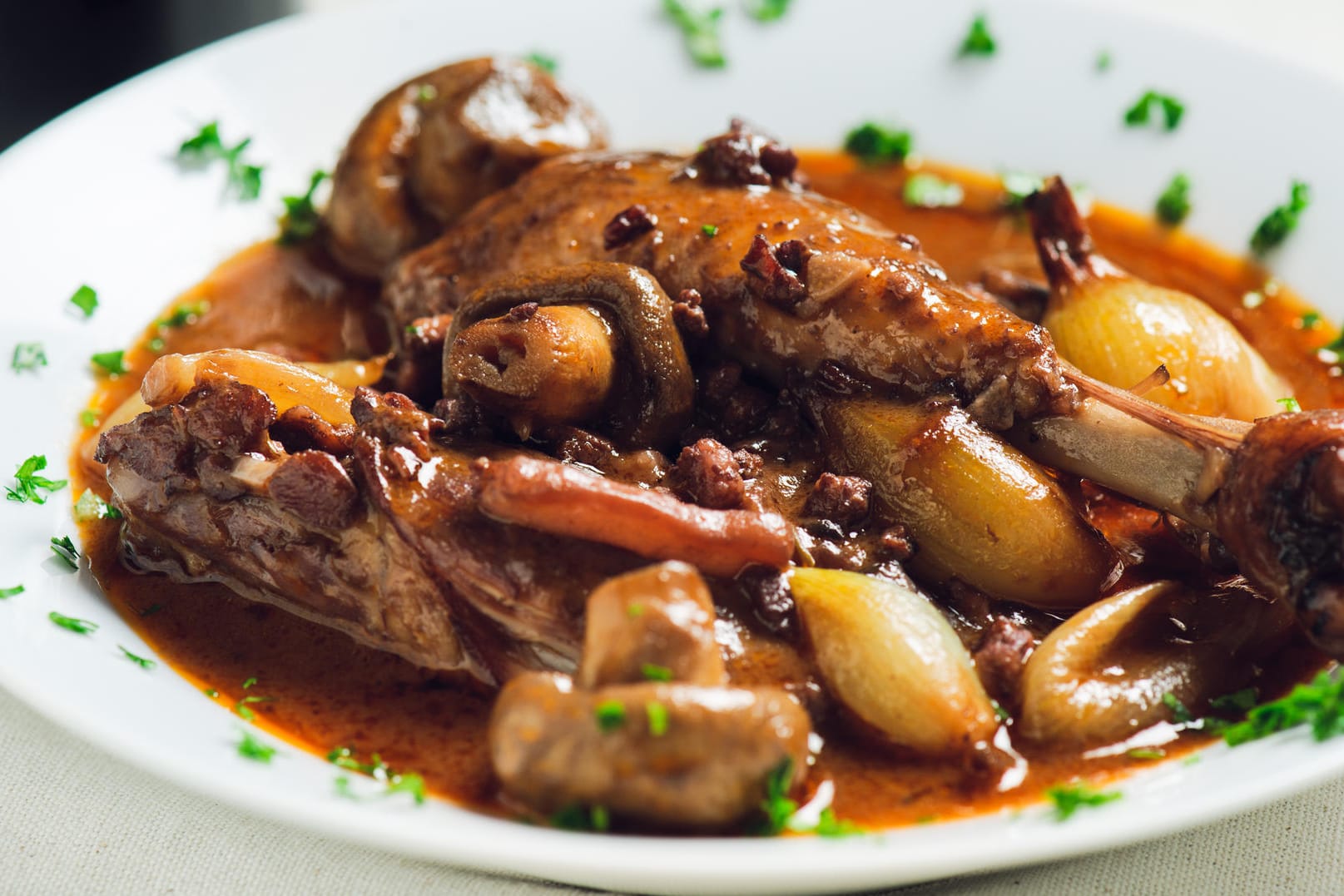 Coq au Vin: Das Fleisch schmort in Rotwein und Fond.