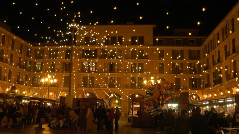 Weihnachtsmarkt in Palma de Mallorca: Weihnachtliche Stände und Livemusik verbreiten feierliche Stimmung bei milden Temperaturen.