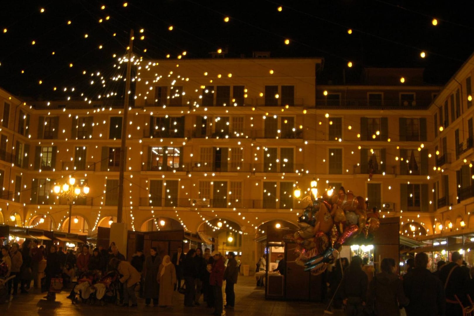 Weihnachtsmarkt in Palma de Mallorca: Weihnachtliche Stände und Livemusik verbreiten feierliche Stimmung bei milden Temperaturen.