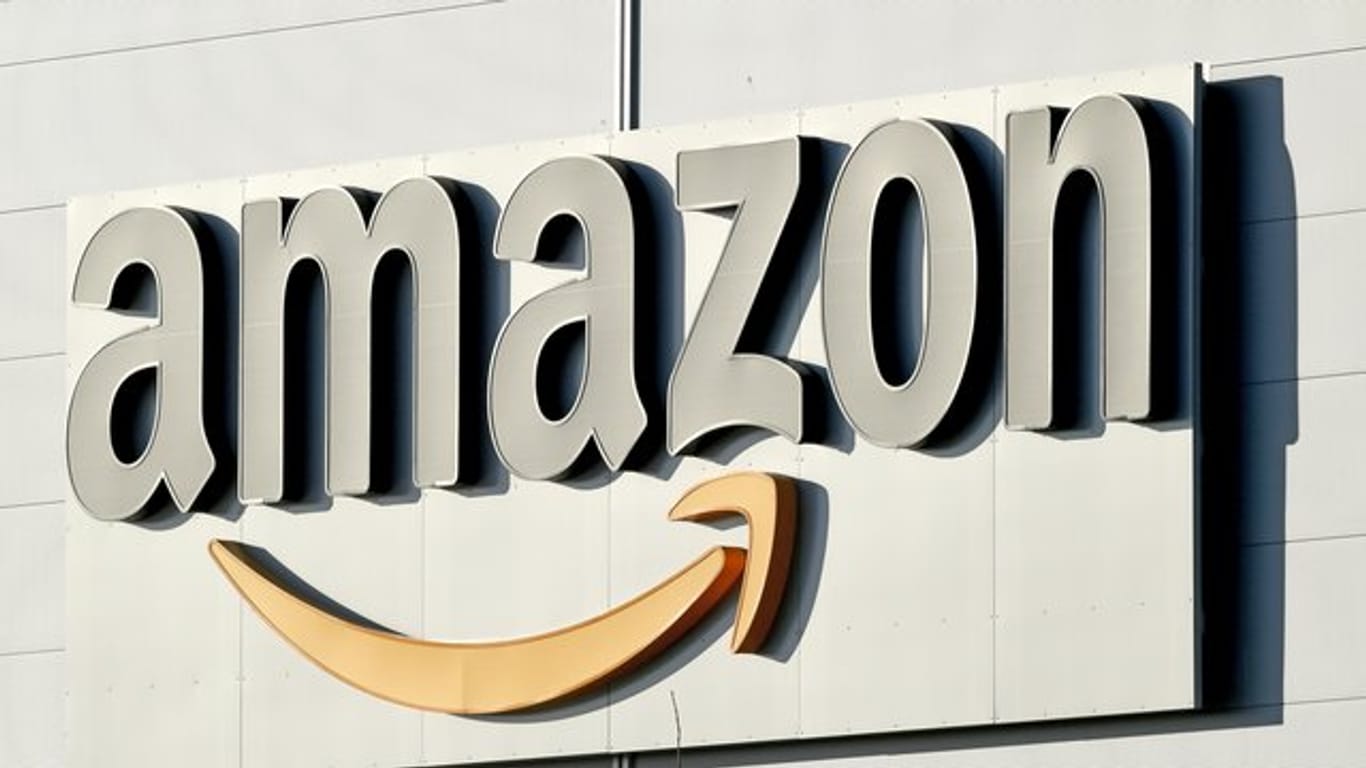 Logo und Schriftzug von Amazon an einem Paketzentrum