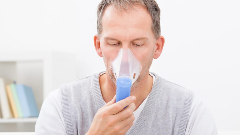 Ein Mann inhaliert Sauerstoff: Das ist eine Maßnahme gegen Cluster-Kopfschmerzen.
