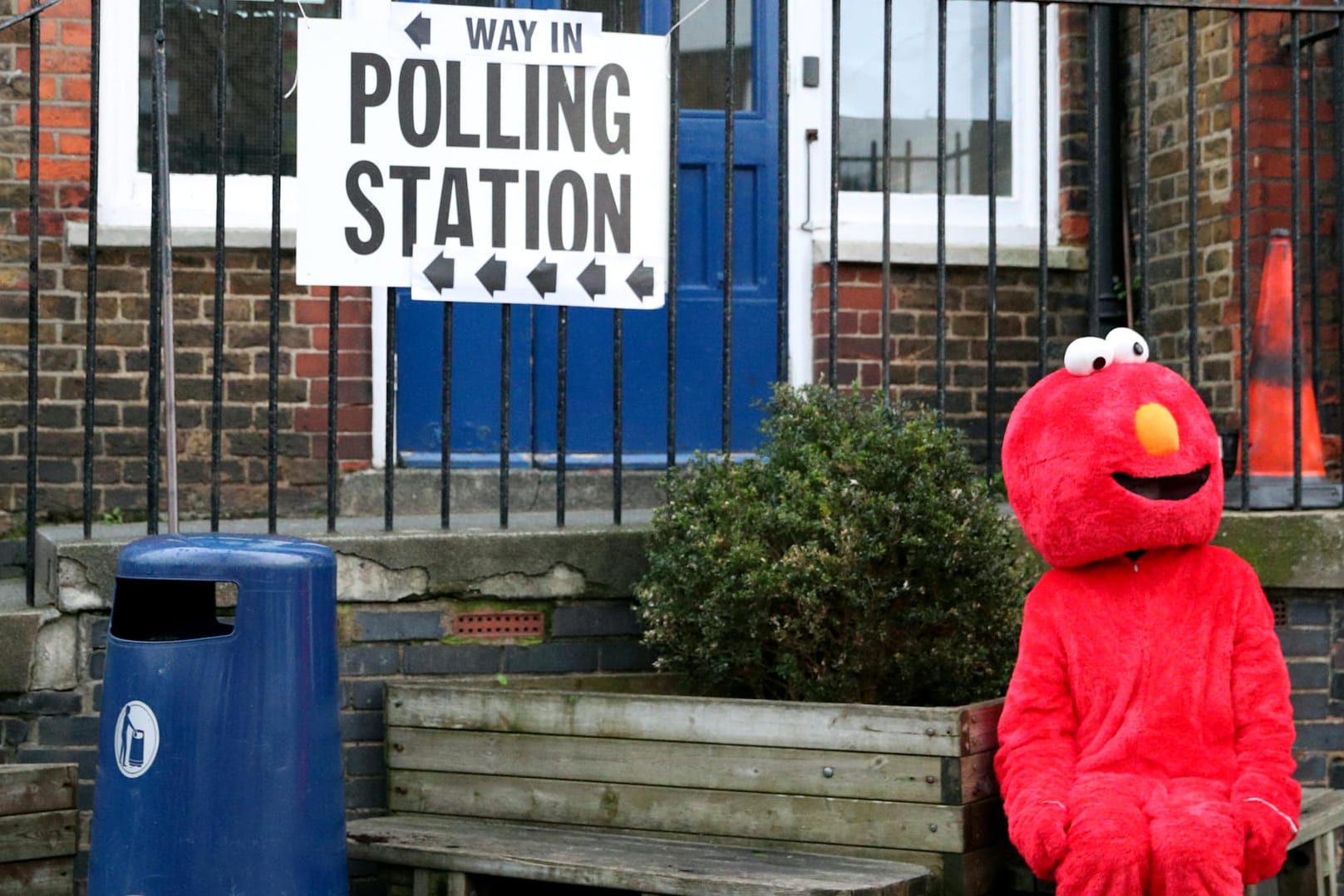 Eine als Elmo verkleidete Frau vor einem Wahlbüro.