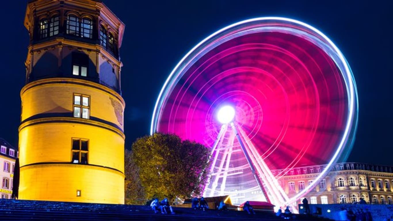Ein rot beleuchtetes Riesenrad in Düsseldorf