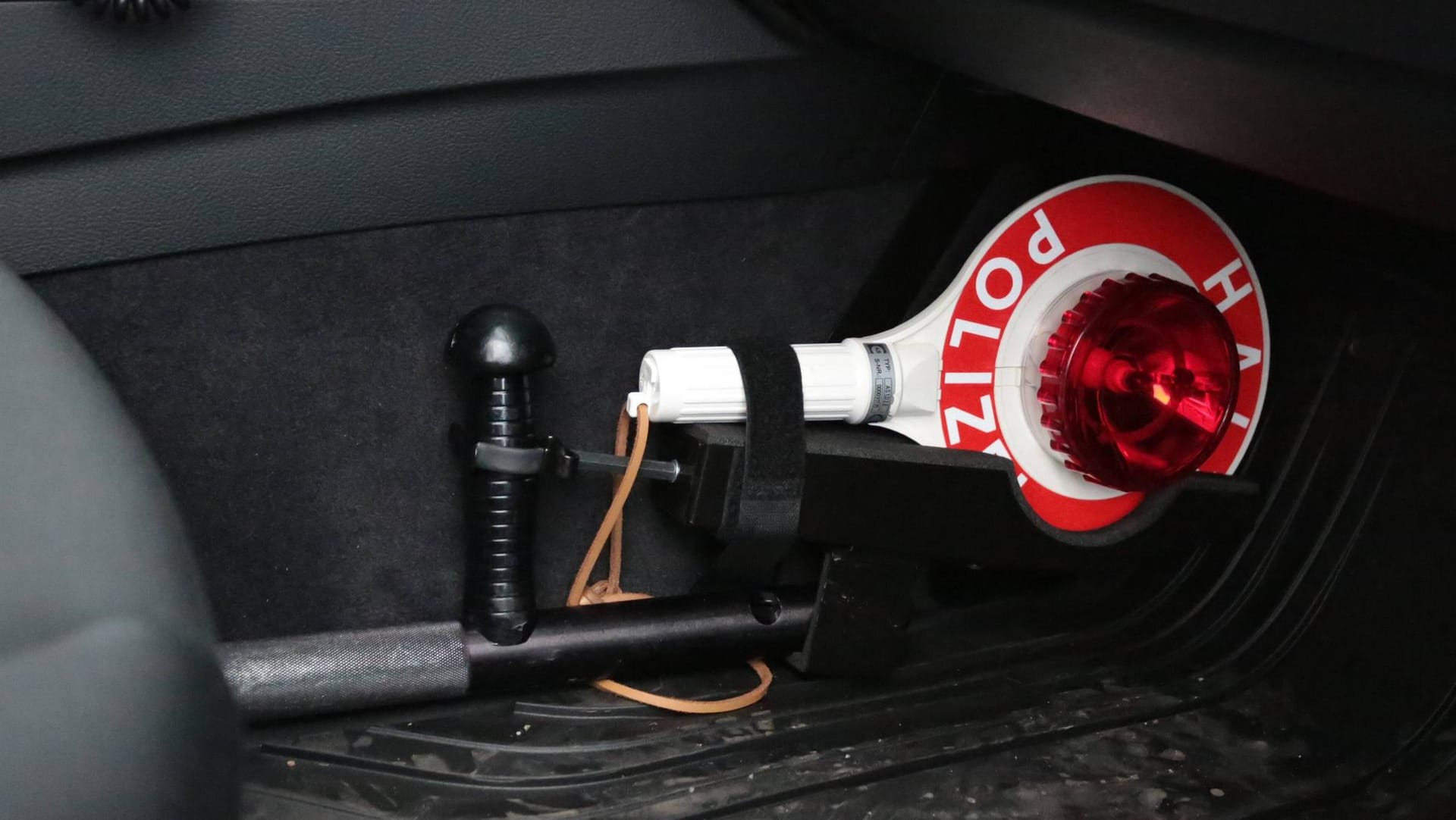 Eine Polizeikelle im Streifenwagen der Polizei: Die Beamten holten den jungen Fahrer an einer Tankstelle ab. (Symbolbild)