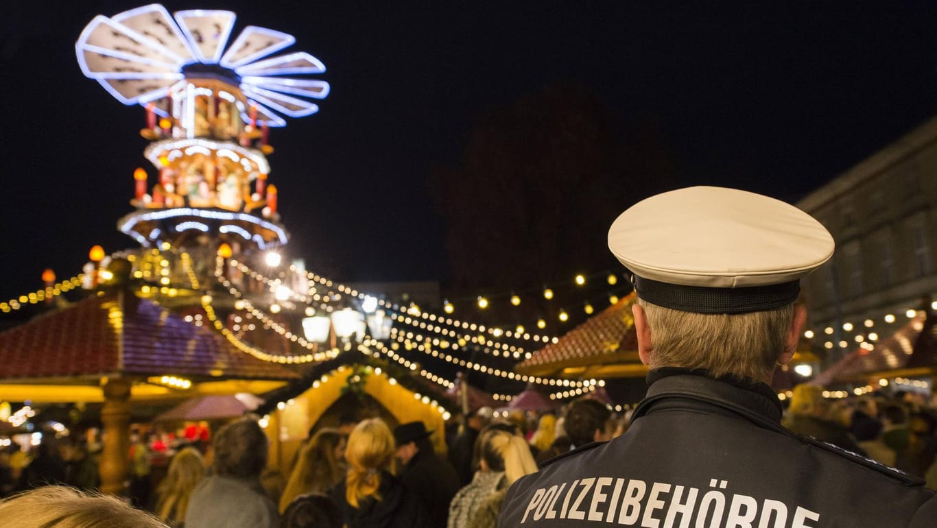 "Polizeibehörde" steht auf dem Rücken eines Uniformierten auf dem Karlsruher Weihnachtsmarkt (Symbolbild): Die Polizei ging hier einem Hinweis einer ausländischen Behörde nach.