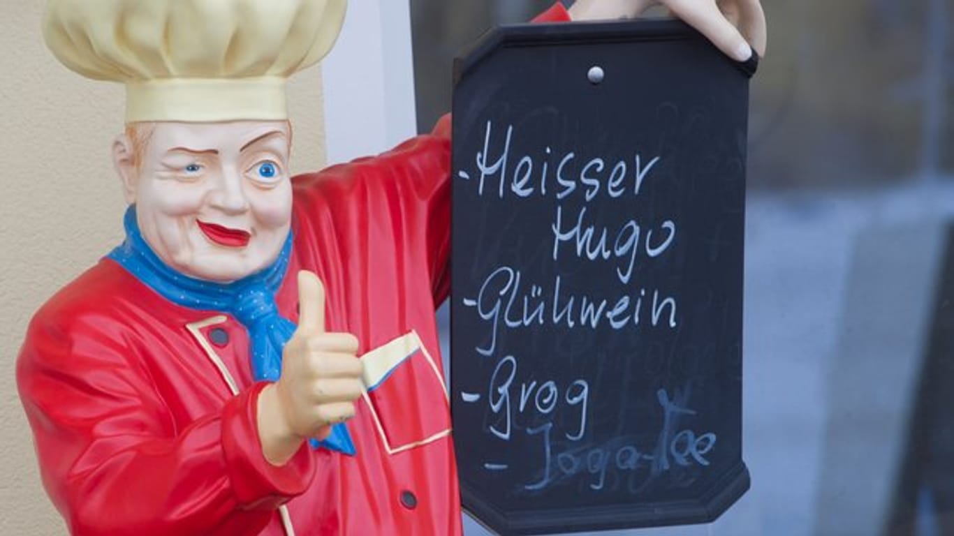 Eine Koch-Figur hält ein Werbeschild: Für Aufregung sorgte in München jüngst der vermeintlich "teuerste Glühwein Deutschlands".