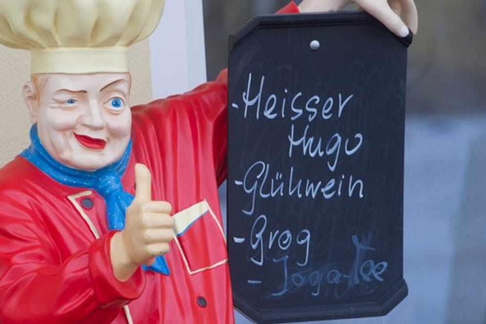Eine Koch-Figur hält ein Werbeschild: Für Aufregung sorgte in München jüngst der vermeintlich "teuerste Glühwein Deutschlands".