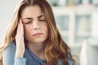 Frau mit Kopfschmerzen: Cluster-Kopfschmerzen, auch Bing-Horton-Kopfschmerzen genannt, gehören neben Spannungskopfschmerzen und Migräne zu den bekanntesten Kopfschmerzarten