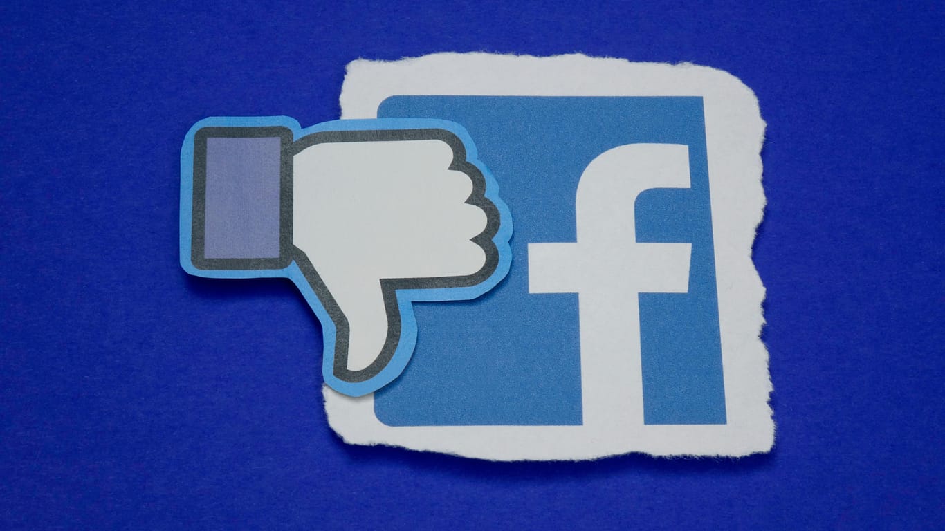 Ein Daumen, der nach unten zeigt, liegt auf dem Facebook-Logo: Die Bundesregierung will die Regeln für soziale Netzwerke verschärfen.