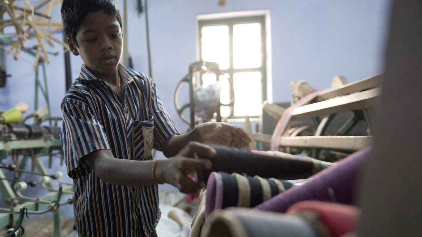Ein Kind arbeitet in einer Textilfabrik in Indien (Symbolbild): In vielen Ländern sind die Produktionsverhältnisse immer noch menschenverachtend.