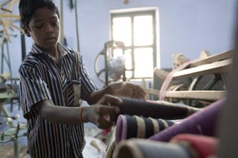 Ein Kind arbeitet in einer Textilfabrik in Indien (Symbolbild): In vielen Ländern sind die Produktionsverhältnisse immer noch menschenverachtend.