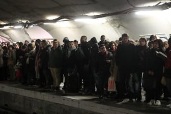 Pendler warten an einem Bahnsteig in Paris vergeblich auf eine U-Bahn.