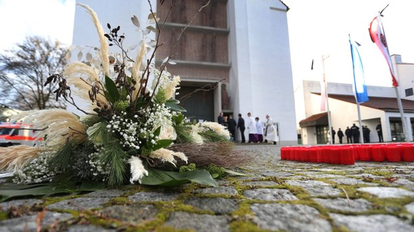 Ein Blumengebinde liegt vor der Kirche in Neusäß bei Augsburg.