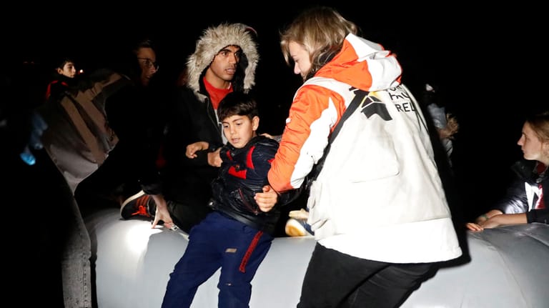 Helfer im Einsatz: Migranten kommen mit einem Boot auf Lesbos an.