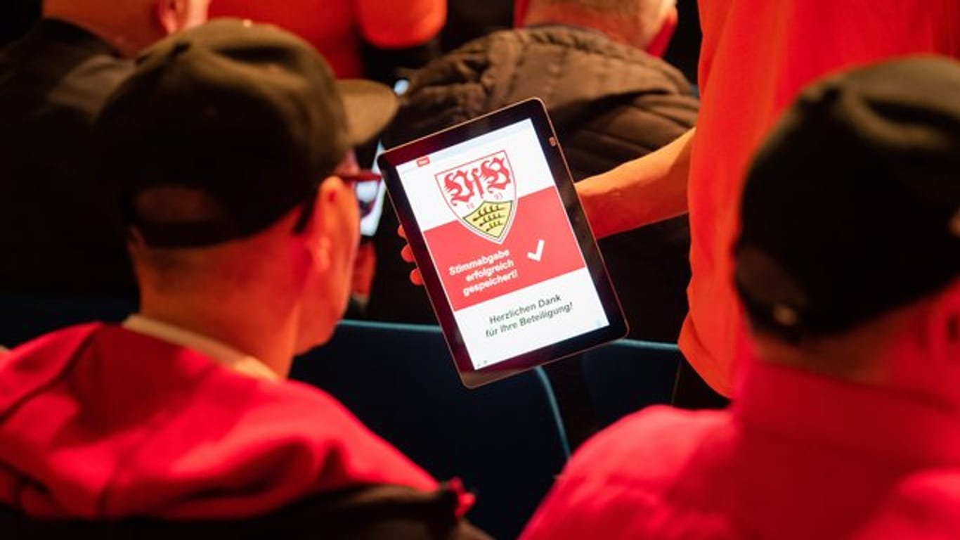 Mitglieder des VfB Stuttgart stimmen in der Hanns-Martin-Schleyer-Halle mit einem Tablet ab.