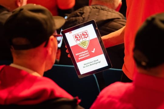 Mitglieder des VfB Stuttgart stimmen in der Hanns-Martin-Schleyer-Halle mit einem Tablet ab.