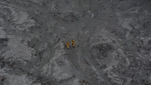 Nach dem Ausbruch: zwei Einsatzkräfte auf White Island. Nach dem Ausbruch: zwei Einsatzkräfte auf White Island.