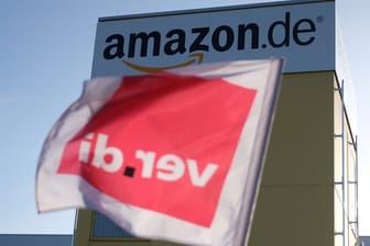 Eine Fahne von Verdi hängt an dem Zaun eines Logistikzentrums von Amazon: Bei Amazon wird seit Mai 2013 in Deutschland immer wieder gestreikt – ohne dass es zu konkreten Ergebnissen kommt.