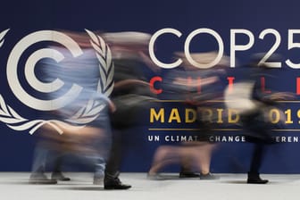Menschen gehen an einem Banner der 25. UN-Klimakonferenz vorbei: Nach 40-Stunden Verhandlung sind nur wenige Kompromisse gefunden worden.