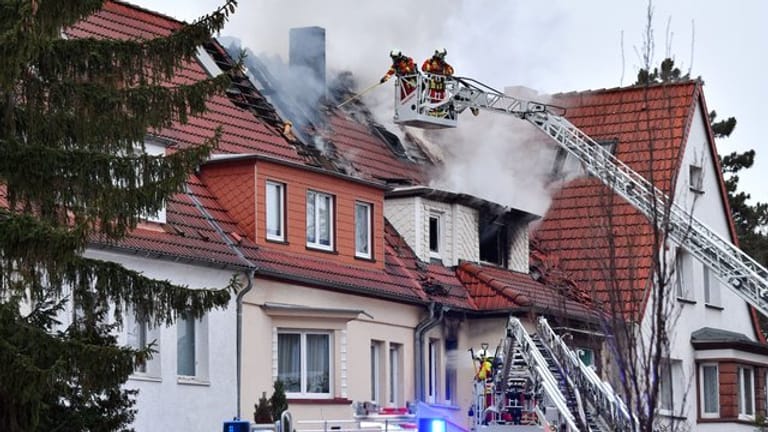 Feuerwehrleute bekämpfen einen Wohnhausbrand